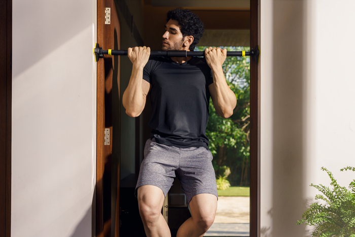 Man doing pull-ups on a Cube Club doorway bar at home