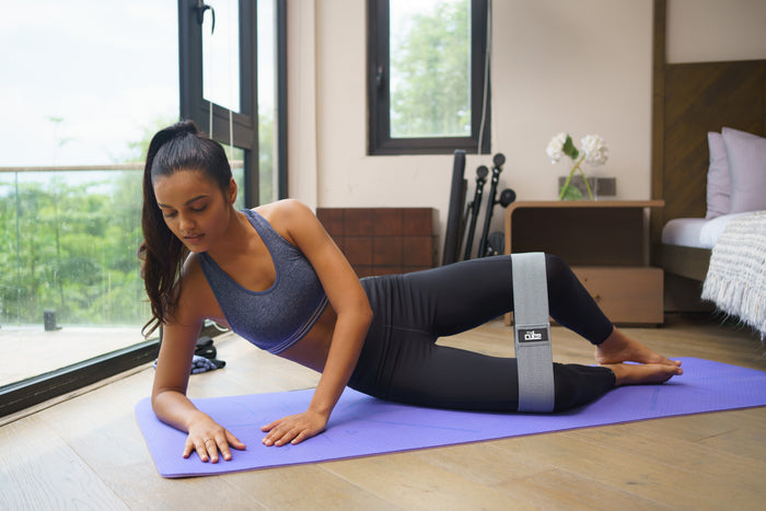 Woman stretching on a Cube Club yoga mat at home